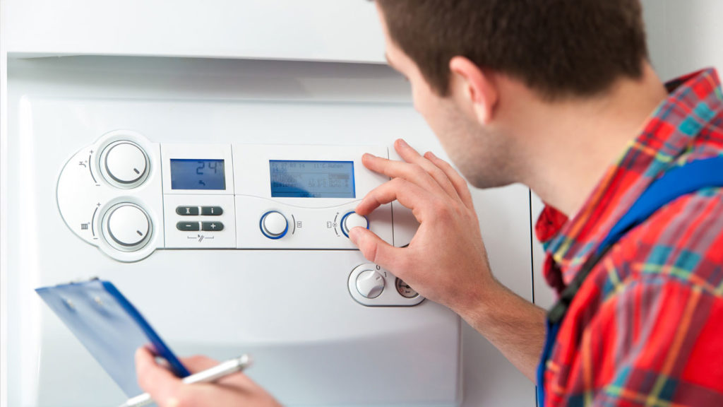 HVAC technician checking a newly installed boiler unit in Milford, CT